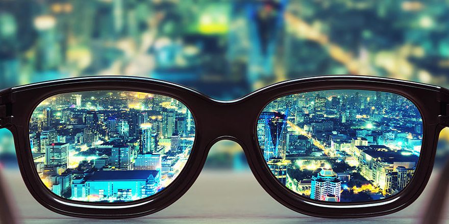 Night cityscape focused in glasses lenses. Vision concept